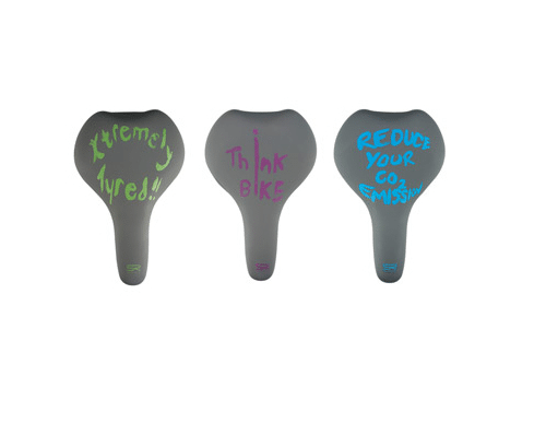 Tre grå cykelsadlar med olika slogans i neonfärger: "Xremely tired!!", "Think bike" och "Reduce your CO2 emission". En minimalistisk stil med starkt ljus och fokus på detaljerna.