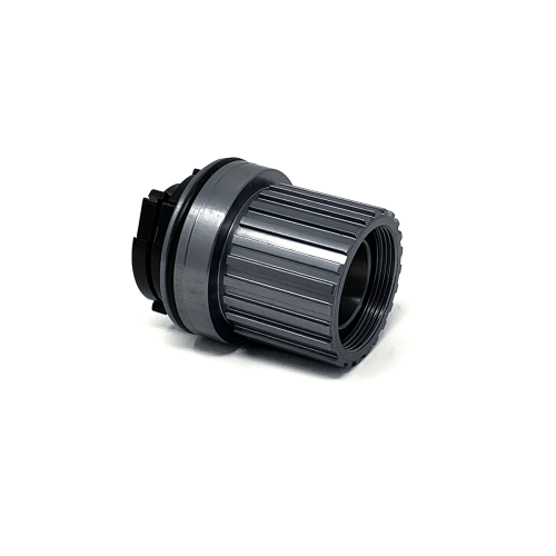 Detaljerad bild av en Shimano Elite-komponent: ett Microspline MTB 12-växlat body, med fokus på den intrikata designen och högkvalitativa finishen. Stark belysning framhäver materialens textur.