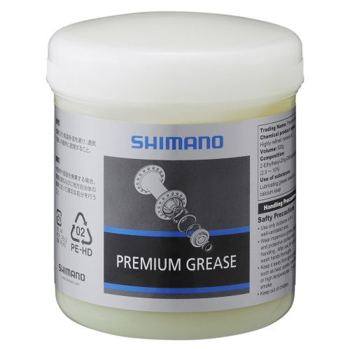 Detaljerad bild av en burk Shimano Premium Grease, avsedd för Dura Ace lagerfett, med produktinformation och säkerhetsföreskrifter tydligt synliga i stark och ren belysning.