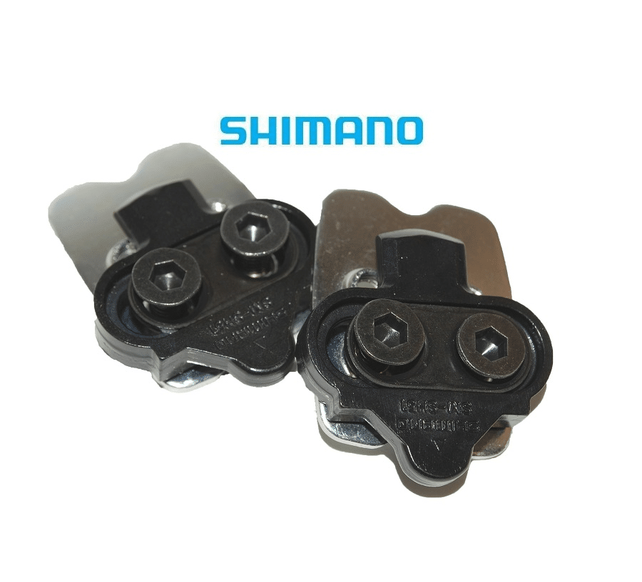 shimano-spd-51-1.png Detaljrik närbild av ett par Shimano SPD SM-SH51 pedalklossar med monteringsplatta. Klossarna är svarta och silverfärgade, placerade mot en vit bakgrund under starkt ljus.
