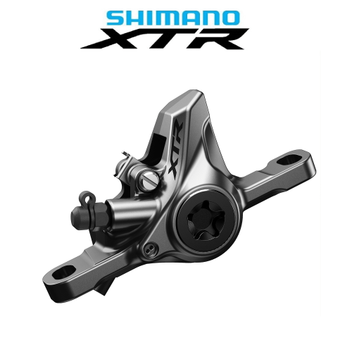 Detaljerad bild av ett Shimano XTR BR-M9100 skivbromsok. Slät metallyta fångar ljuset, med fokus på dess konstruktion och design. Logotypen "Shimano XTR" syns tydligt ovanför.