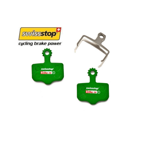 Två gröna Swissstop Disc 26 bromsbelägg och en silverfärgad hållare visas mot en vit bakgrund. Logotypen "Swissstop" syns tydligt med texten "cycling brake power" nedanför.