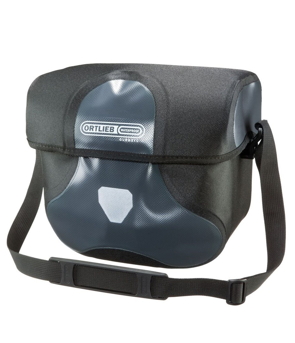 ultimate-six-classic-85l.jpg Ortlieb Ultimate Six Classic 8,5 liter är en svart och grå vattentät axelremsväska med frontklaff, justerbar rem och en framträdande logotyp på framsidan.