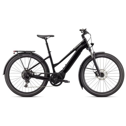 Svart Specialized Turbo Vado 4.0 ST damcykel i profil, mot en vit bakgrund. Cykeln har skärmar och pakethållare, belysning och dämpad framgaffel. Detaljerad och välbelyst bild.