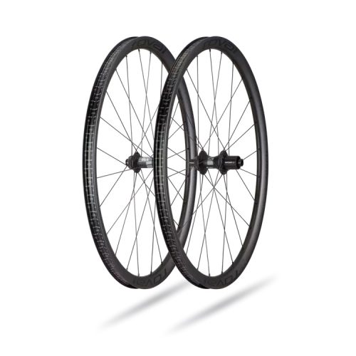 Ett par Roval Terra CL-cykelhjul i kolfiber, avsedda för gravelcykling, med skivbromsfästen, presenteras i ett ljust rum med mjuka skuggor.