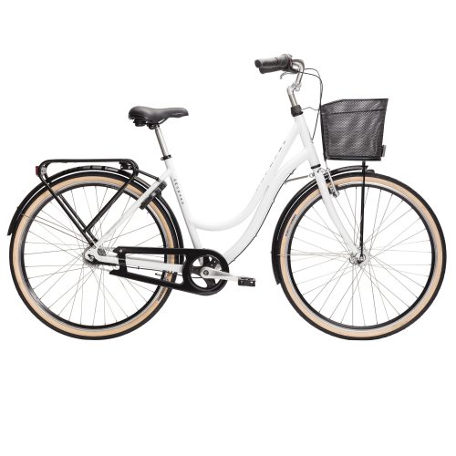Den här detaljerade bilden visar en vit Monark Monica 7-vxl damcykel med korg och pakethållare. Elegant design i ljus studiobelysning, perfekt för en klassisk cykeltur.