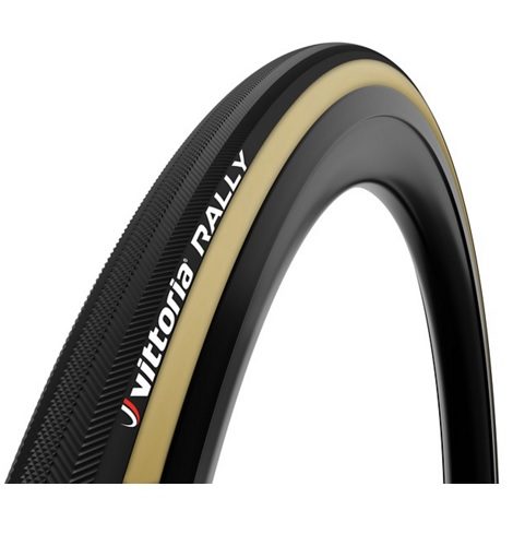 Ett cykeldäck Vittoria Rally visas i studioljus, svart med beige sidovägg och däcksstruktur syns tydligt. Vittoria-logotypen framhävs. Däcket är monterat på en fälg, vilket ger en komplett bild.