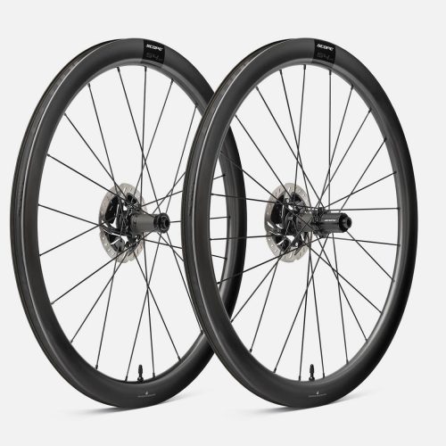 Två Scope S4.A 45 mm disc hjulpar visas i en studio med mjukt ljus. De kolfiberfälgar och navens detaljer är tydliga. Hjulens design framhävs mot en neutral bakgrund.