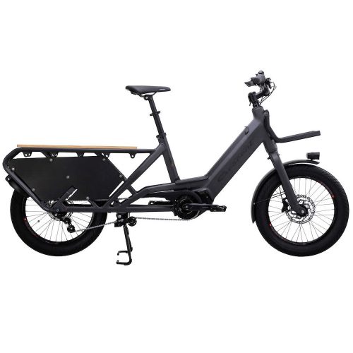 Svart Crescent Elast 20 lastcykel i profil, med träpanel bak. God belysning framhäver detaljerna på denna praktiska och stilrena transportlösning.
