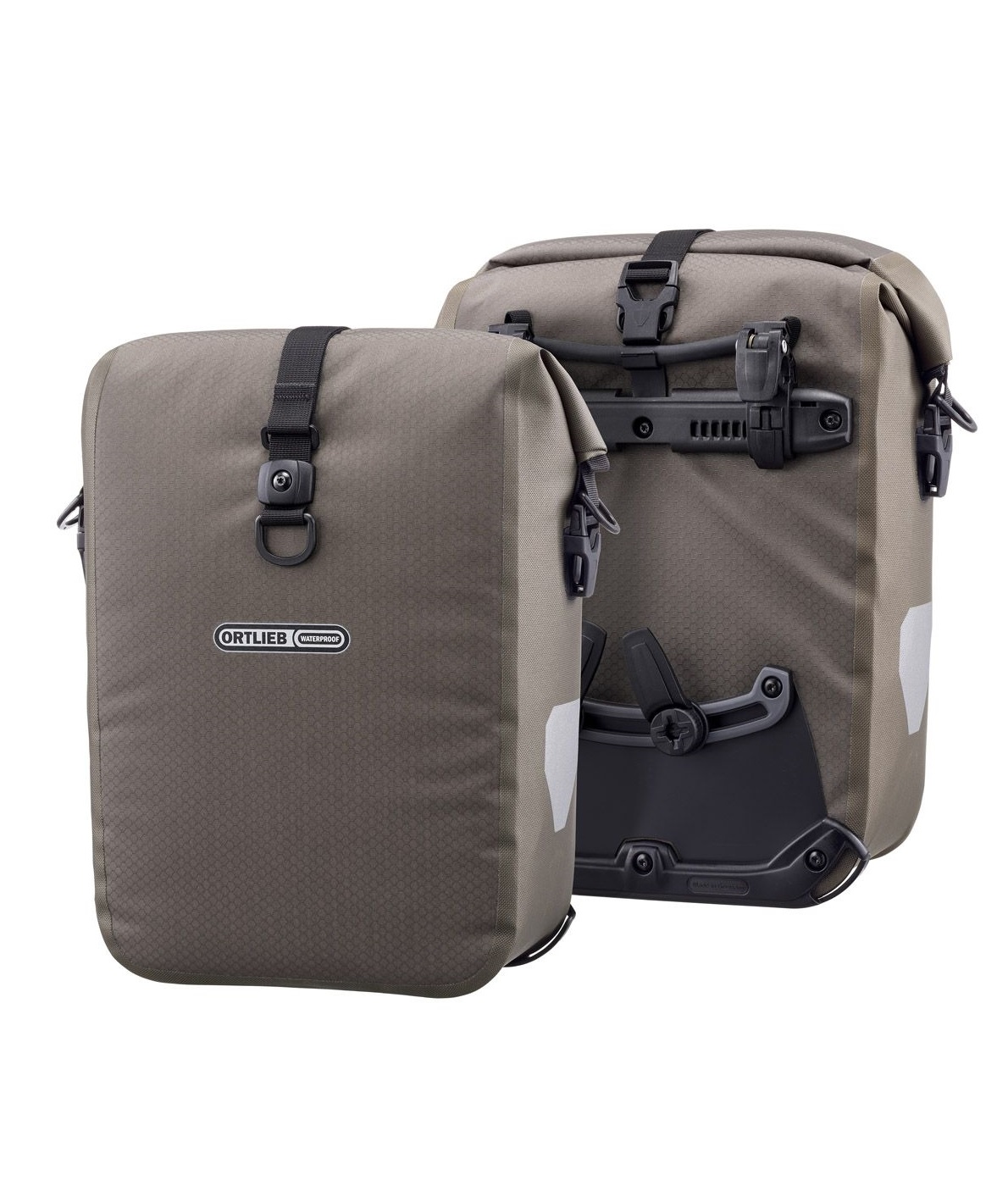 gravel-pack-dark-sand Två bruna Ortlieb Gravel-pack framväskor står mot en vit bakgrund, monterade med ett robust svart fästsystem. Detaljer som logotyp, spännen och reflexer framhävs i det jämna ljuset.