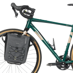 Cykel med Basil Navigator Storm sidoväska i grått och svart, monterad på framhjulet. Väskan är robust och har detaljer som elastiska snören och ett vattentätt material.