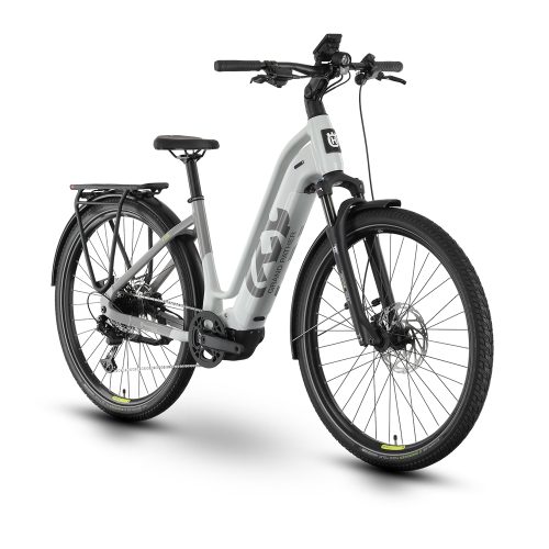 En grå Husqvarna Grand Pather 4 elcykel för damer, stående i en studio med mjukt ljus, framhäver cykelns design och komponenter.