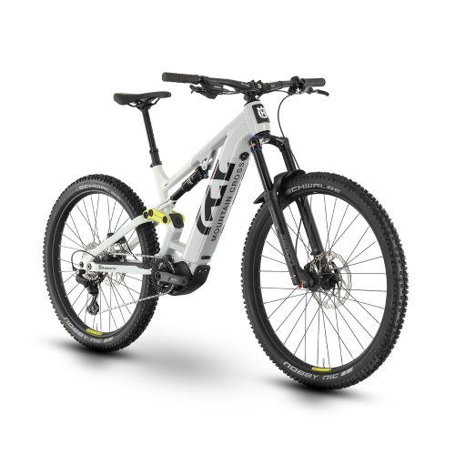 Vit Husqvarna Mountain Cross MC1 el-MTB med mullet-konfiguration. Den står i ett ljust utrymme, vilket framhäver detaljerna i dess dämpning och däck.