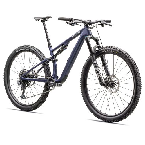 Detaljerad bild av en blå Specialized Epic 8 EVO Comp mountainbike. Den har dämpning fram och bak, kraftiga däck och avancerade komponenter. Studiofotografering med jämnt ljus framhäver cykelns design.