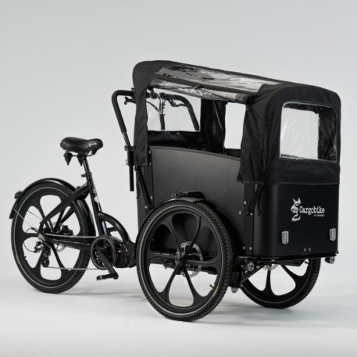En svart Cargobike Delight lastcykel står på en vit bakgrund. Detaljer som hjul, sadel och lastboxens skydd syns tydligt i det jämna ljuset.
