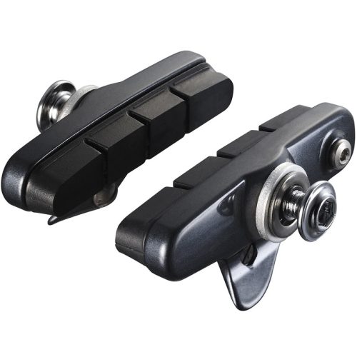 Två Shimano Ultegra 6700/R55C2 bromsskor visas i en detaljerad studiobild med neutral bakgrund. Svart gummi och silverfärgade monteringsdetaljer framhävs av jämn belysning.