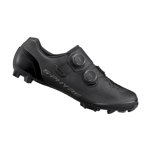 En detaljerad bild av en mattsvart Shimano SH-XC903 S-Phyre MTB-sko, framhävd i studioljus, visar de dubbla BOA-spännena och den aggressiva yttersulan.