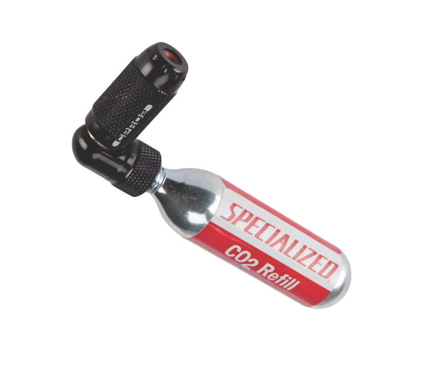 Specialized Kolsyrepump 4722-4055 Kolsyrepump Specialized CPRO2 Trigger Ink kopplad till en 16g kolsyrepatron. Belysningen är jämn och framhäver detaljerna på pumpens svarta textur och patronens röda etikett.
