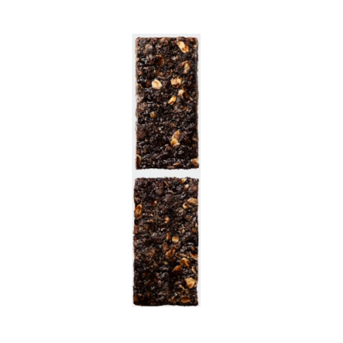 Två mörka energibars, åtskilda av en liten mellanrum, ligger vertikalt på en ljus bakgrund. Belysningen är jämn och framhäver texturer av kakao och nötter i baren.