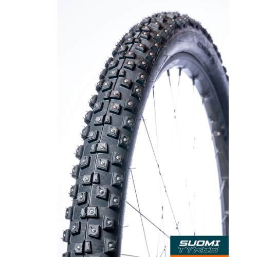Närbild av ett cykeldäck med dubbar, troligen ett Suomi Tyres Piikkisika däck, med skarpt ljus som framhäver detaljerna och den robusta designen för vinterförhållanden.