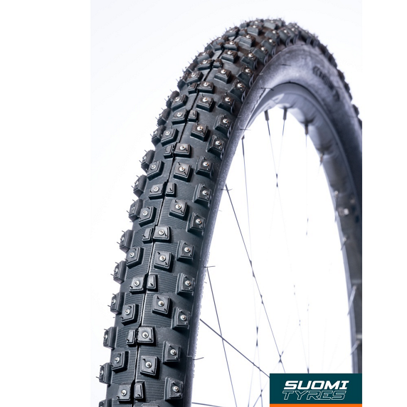T500081_396.jpg.thumb.572.572 Närbild av ett cykeldäck med dubbar, troligen ett Suomi Tyres Piikkisika däck, med skarpt ljus som framhäver detaljerna och den robusta designen för vinterförhållanden.