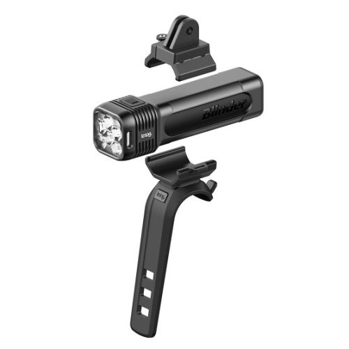 En svart Knog Blinder 1300 lumen framlampa med tillbehör, fristående mot en vit bakgrund. Lampan, fästet och en kameraadapter visas i detalj med stark belysning som framhäver formerna.
