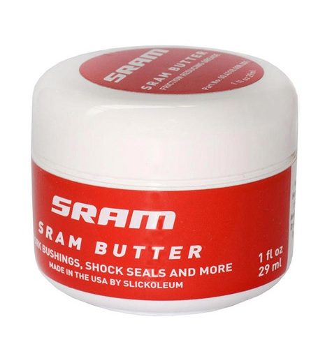 Vit burk med röd etikett "SRAM Butter", för SRAM XX, X0, Roam, Rise baknav, RockShox gafflar och Reverb stolpar. Ljuset är jämnt och atmosfären är ren.