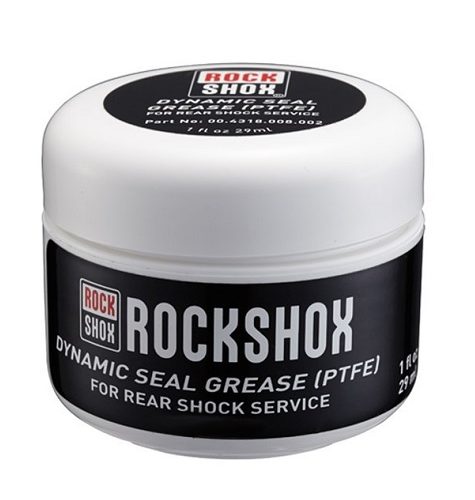En burk Rockshox Dynamic Seal Grease (PTFE) avbildas mot en vit bakgrund. Burken har en vit topp och en svart etikett med vit text, vilket ger en ren och professionell känsla.