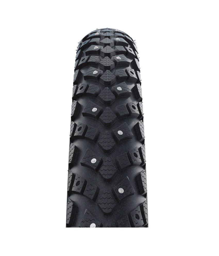 Schwalbe-Winter-50-584 Närbild av ett Schwalbe Marathon Winter dubbdäck, 27,5 tum. Däcket har ett distinkt mönster med många dubbar för säkert grepp på is och snö. Starkt ljus framhäver detaljerna.