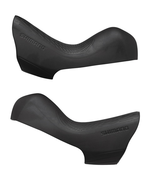 Shimano-Hoods-ST-R8020 Två svarta Shimano Ultegra ST-R8020 reglage skydd visas mot en ren vit bakgrund. Fokus ligger på detaljerna i gummit och den präglade "SHIMANO" logotypen. Mjukt, diffust ljus framhäver texturerna.