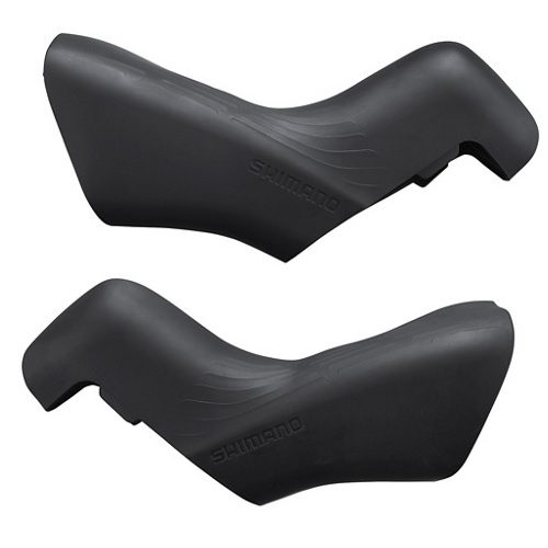 Ett par svarta Shimano reglageskydd för 105 ST-R7100 visas mot en ljus bakgrund. Skydden har en texturerad yta och är formade för optimalt grepp och aerodynamik. Produktdetaljer tydliga.