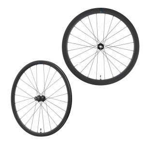 Två hjul av modellen Shimano 105 WH-RS710-C46 Carbon Disc, med tunna svarta ekrar och djupa kolfiberfälgar, visas sida vid sida mot en vit bakgrund; det mindre framhjulet är vinklat åt vänster, medan det större bakhjulet visas rakt framifrån till höger.