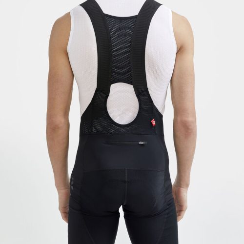 Svarta Craft ADV Gravel-cykelshorts med hängslen, sedda bakifrån, bärs med ett vitt linne.