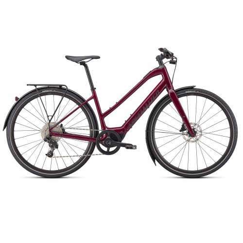 El-cykeln Specialized Turbo Vado SL 4.0 ST är en vinröd elcykel med en genomgående ram, platt styre, skivbromsar, pakethållare, skärmar och smala landsvägsdäck, visad i profil mot en vit bakgrund.