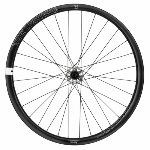 Ett svart Hjulpar American Classic, 27,5″ Disc Boost – XD-cykelhjul med tunna metallekrar, ett centralt nav och texten ”WIDE LIGHTNING” på fälgen. Fälgen är märkt med ”VINDY” längst ned och ”ATOMICARBON” på höger sida. Detta hjul, som är inspirerat av American Classic-designen, sticker ut mot en ren vit bakgrund.