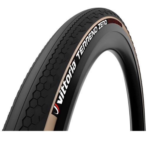 Närbild av ett Graveldäck Vittoria Terreno Zero, Svart - 40-622 mm cykeldäck med solbruna sidoväggar, hexagonalt slitbanemönster och synligt varumärke, mot en vit bakgrund.