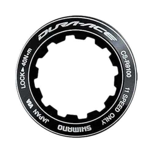 En svart Shimano Dura-Ace CS-R9100 låsring med "LOCK 40Nm" och "JAPAN" i vit text, utformad för att säkra en kassett; Produktnamn: Distans och låsring till Kassett Shimano Dura-Ace CS-R9100.