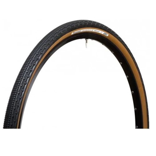 Graveldäck Panaracer Gravelking Svart/brun (40-622/43-622 mm) har en brun sidovägg, svart slitbana med texturerat mönster och visas monterad på en svart fälg med ventilstammen synlig längst upp.