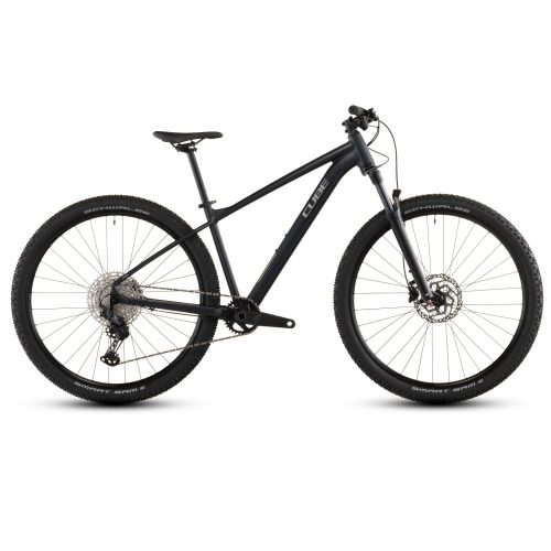 En sidovy av MTB 27,5" Cube Attention Pro, 1x12-växlad i matt svart visar det raka överröret, det platta styret, framfjädringen, skivbromsarna och knobbydäcken mot en vit bakgrund.