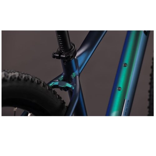 Närbild av MTB 29" Cube Reaction Pro 1x12s i goblin´n´black, som framhäver sadelstolpen, bakhjulet och ramdetaljerna med sin metalliskt blågröna finish mot en mörk bakgrund.