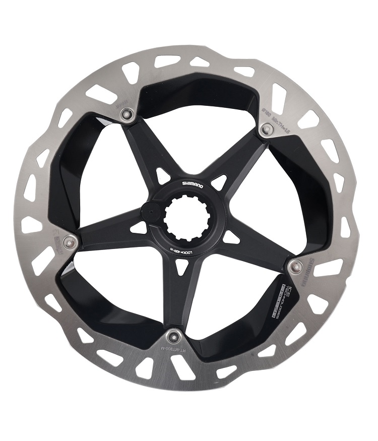 Shimano-RT-MT900-icetech-frezza-sj En närbild av Bromsskiva Shimano XTR/Dura Ace RT-MT900 CL skivbromsrotor visar dess silverkant, svarta ekrar, fem monteringspunkter och synliga varumärke. Bland funktionerna finns en låsring med magnet.
