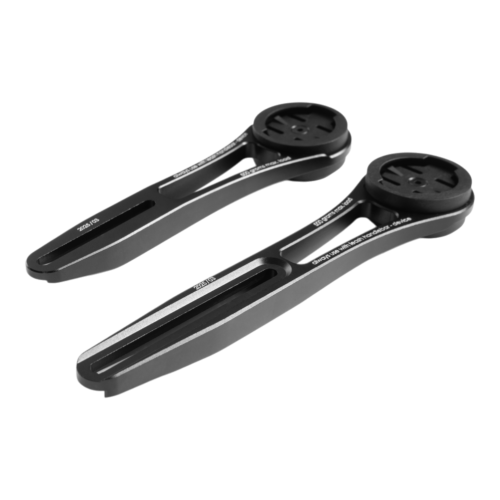 Två svarta Cube/ACID Datoradapter Navigation Mount X-Lock cykeldatorfästen i plast visas sida vid sida på en vit bakgrund, båda med en cirkulär hållare i ena änden och en slitsad arm som sträcker sig ut från den.