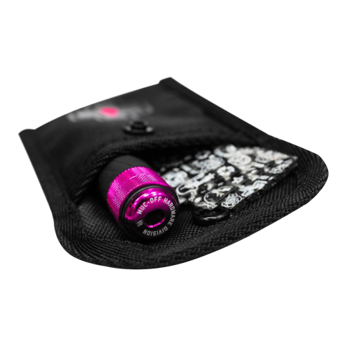 En svart tygpåse, delvis öppen, avslöjar den metallicrosa MUC-OFF Precision Tubeless Repair Capsule (Punkaverktyg för att plugga däck) och ett litet kort med svartvita mönster inuti.