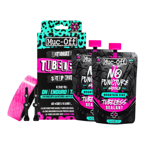 Muc-Off Ultimate Tubeless Setup Kit för mountainbikes, inklusive två svarta tätningspåsar, två svarta ventiler, en rulle rosa fälgtejp och en produktförpackning med turkosa och rosa accenter.