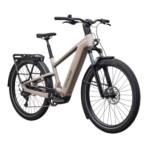 En Specialized Vado 3.0 elcykel i beige med en robust ram, svarta hjul, skivbromsar, lasthållare bak och fjädring fram visas på en vit bakgrund.