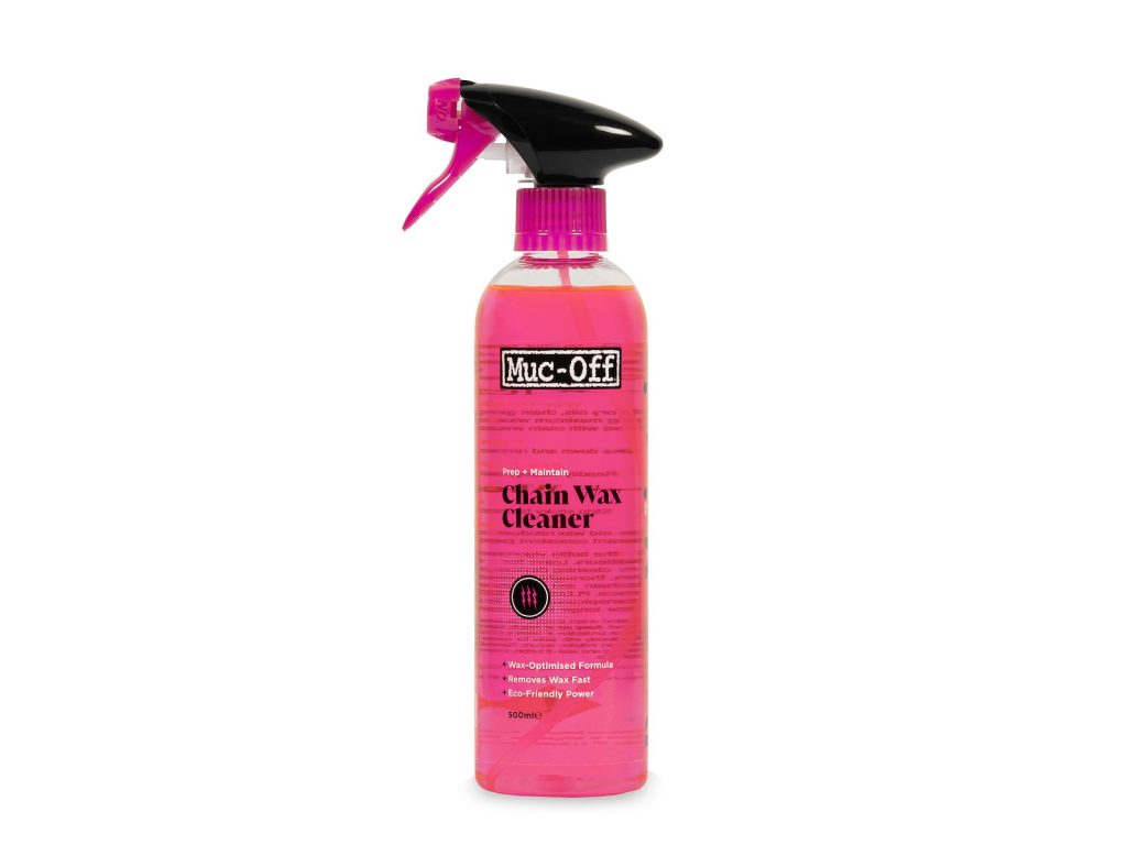 En rosa sprayflaska märkt "Muc-Off Chain Wax Cleaner" med ett svart munstycke, stående upprätt mot en vit bakgrund.