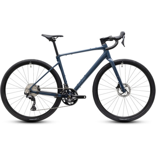 Gravel Cube Nuroad Race, 2x12s – Blå visas från sidan mot en vit bakgrund, där dess drop-styre, skivbromsar och knubbiga däck framhävs. Denna blå gravelcykel har en drivlina med dubbla kedjedrev och en elegant, lätt ramkonstruktion.