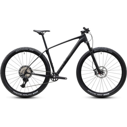 MTB 29 Cube Reaction C:62 ONE, XT 1x12 – som finns i svart eller lila – är en hardtail-mountainbike utrustad med 29-tums hjul, en framgaffel med fjädring, rakt styre, skivbromsar och Schwalbe-däck. Den visas i profil mot en vit bakgrund.