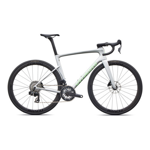 En landsvägscykel med vit och grå ram, drop-styre, svart sadel och svarta hjul med märkningen ”Roval”. Cykeln är utrustad med skivbromsar och en synlig växelmekanism.