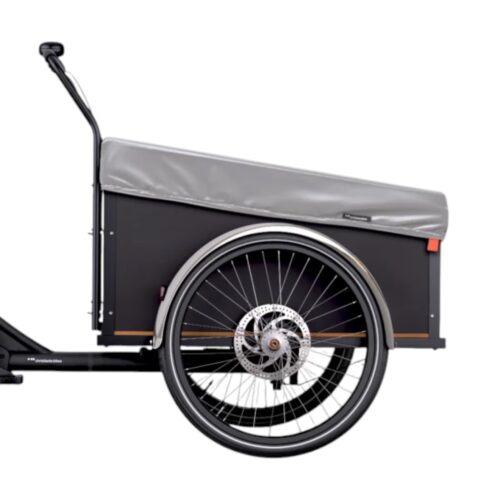 En närbild från sidan av en svart lastcykel med en rymlig förvaringslåda framtill, skyddad av Christiania Bikes Regnskydd för låda – Silver, och med ett enda stort hjul med synliga ekrar och skivbroms mot en enfärgad vit bakgrund.